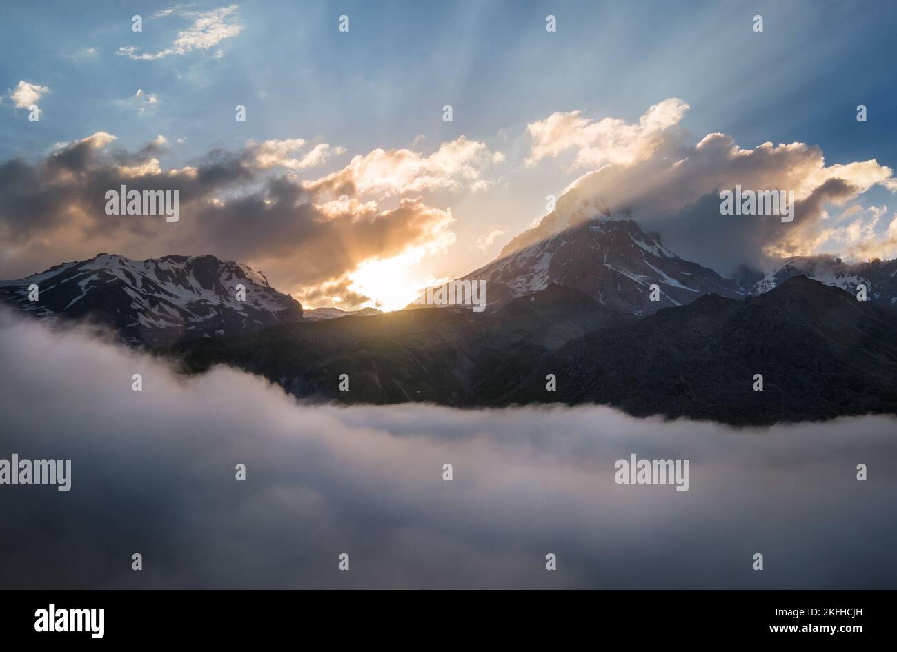 Kazbek 5054m Berg übersät mit Sonnenuntergang Licht über den fließenden tief verlaufenden Wolken, Kaukasus, Georgien Stockfoto