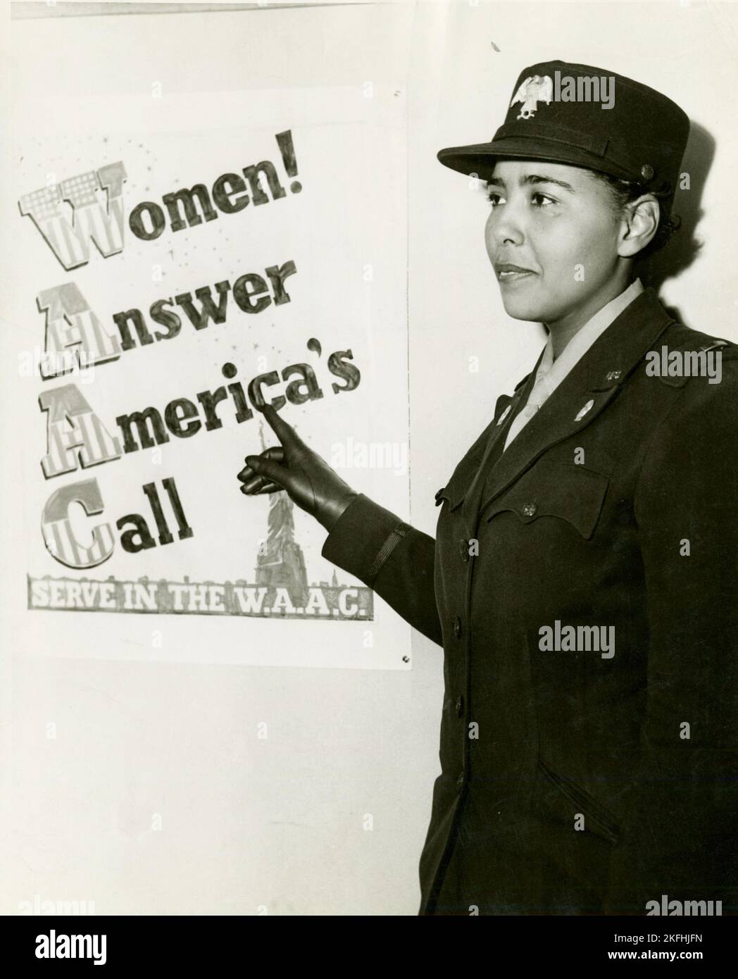 African American Charity Adams, First Officer im Hilfskorps der Frauenarmee, stand in Uniform und zeigte auf ein Plakat mit der Aufschrift: "Frauen! Beantwortet Amerikas Ruf, dient in der W.A.C.“, 1943-02. Stockfoto