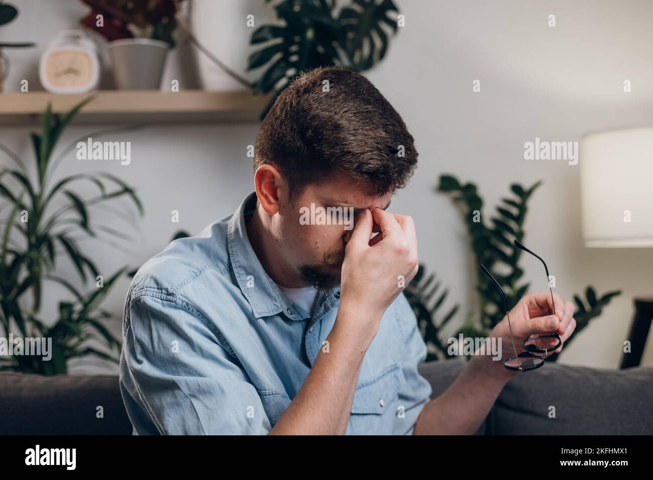 Nahaufnahme des müden jungen männlichen Computerbenutzers nimmt die Brille ab massiert trocken juckende, reizende Augen fühlen sich Augenbelastung an. Überarbeitter Telearbeiter löst t Stockfoto