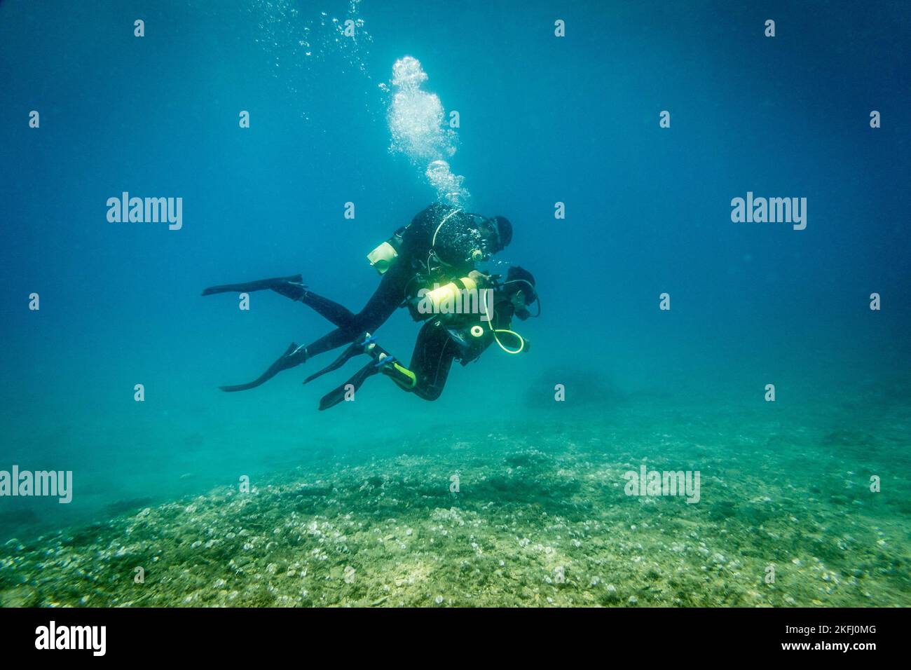Kaukasischer Vater mit Sohn tauchen und gemeinsam unter tiefem Wasser im blauen Meer während des Urlaubs das Meer erkunden Stockfoto