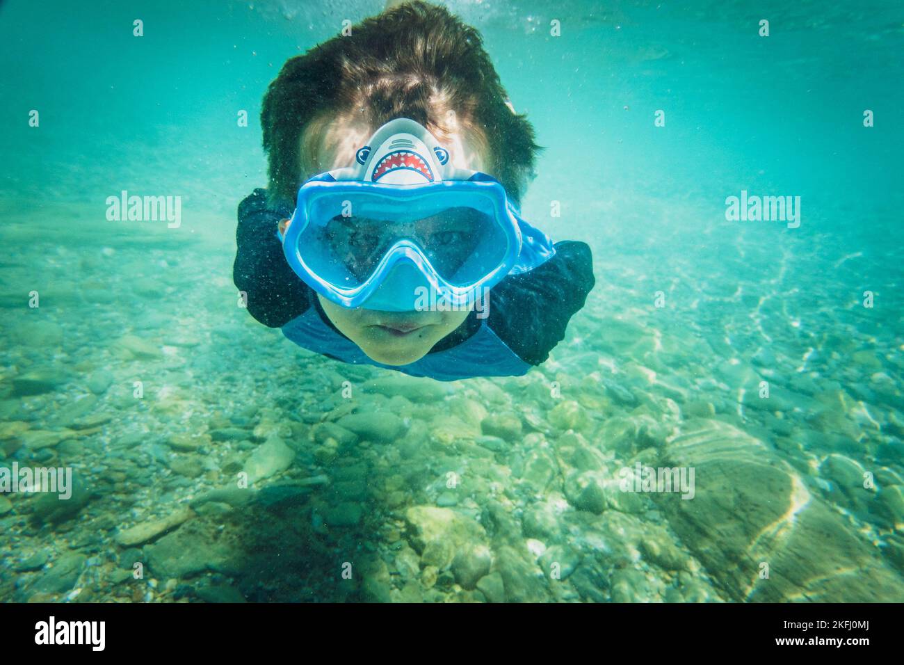 Porträt eines sorglosen Jungen mit blauer Schwimmbrille und beim Tauchen unter Wasser auf dem Meer Stockfoto