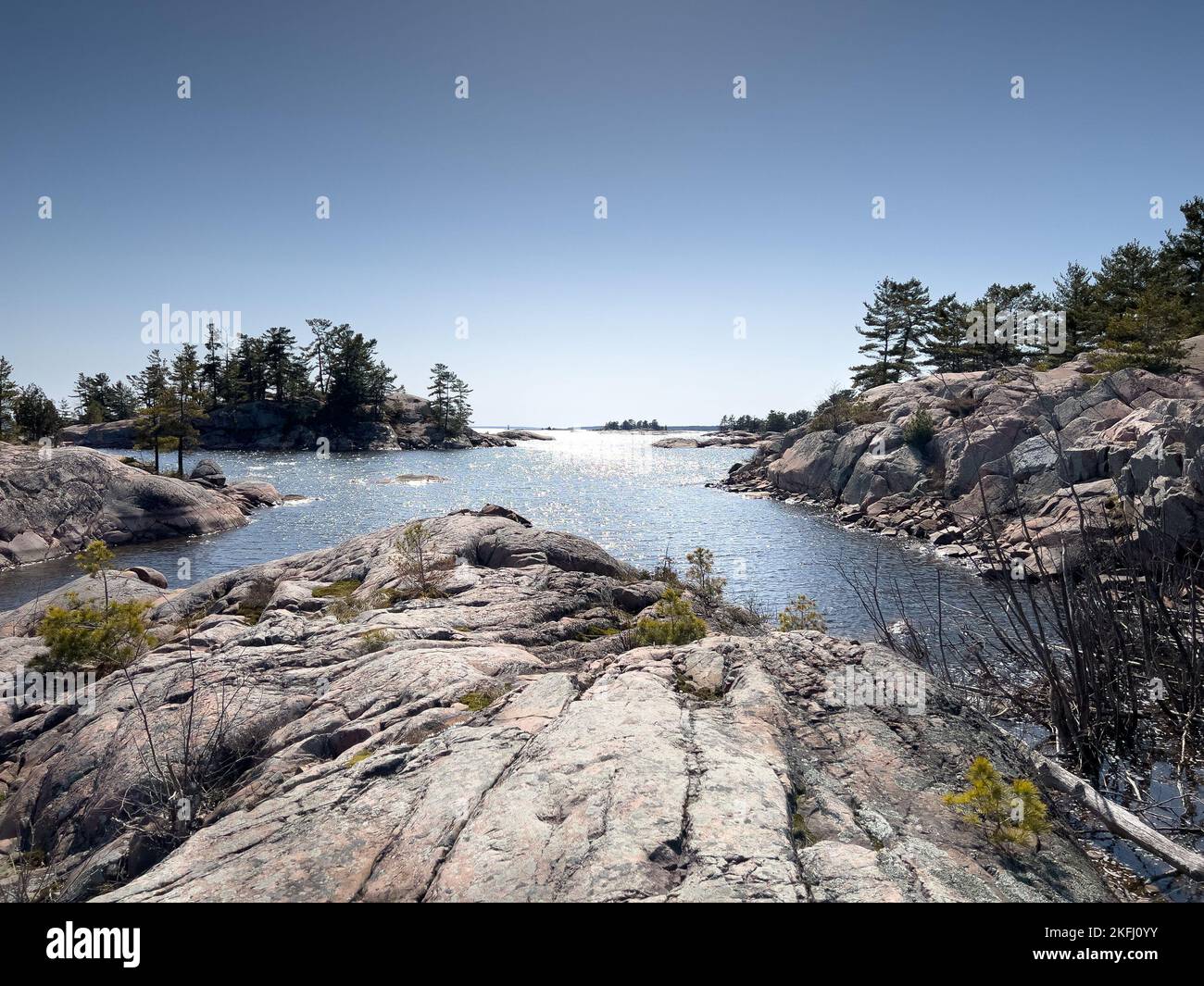 Ruhiger Blick auf das Meer und die Felsformationen an der Küste vor dem klaren blauen Himmel an sonnigen Tagen Stockfoto