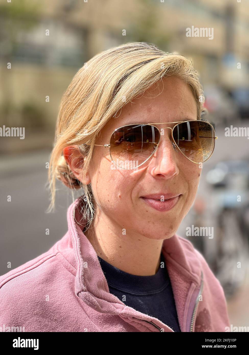 Nahaufnahme eines lächelnden mittleren Erwachsenen mit blonden Haaren und Sonnenbrillen an sonnigen Tagen im Freien Stockfoto