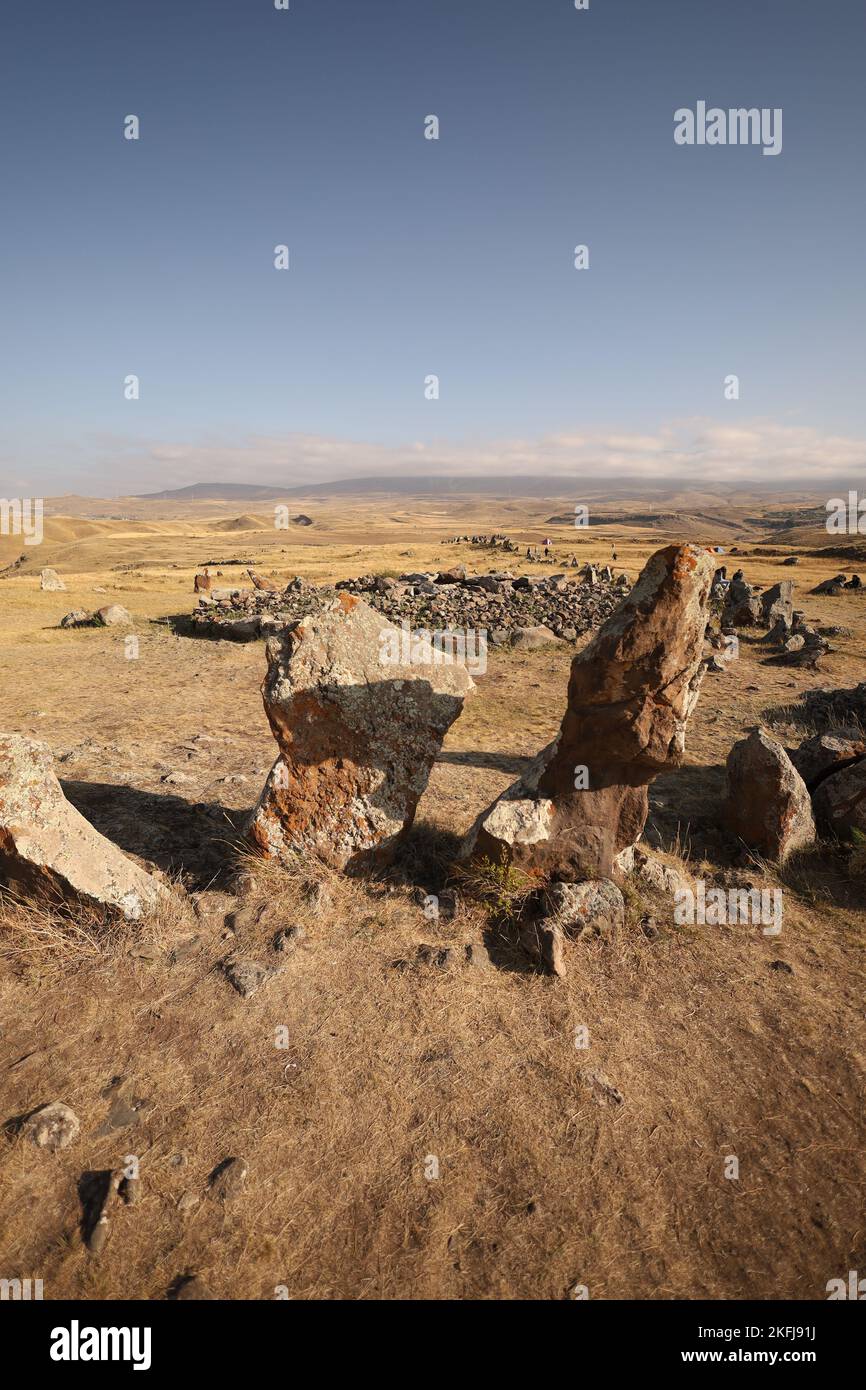Eine vertikale Ansicht einer archäologischen Stätte mit prähistorischen Megalithen in Armenien, auch bekannt als "Armenian Stonehenge", einem blauen Himmel im Hintergrund Stockfoto