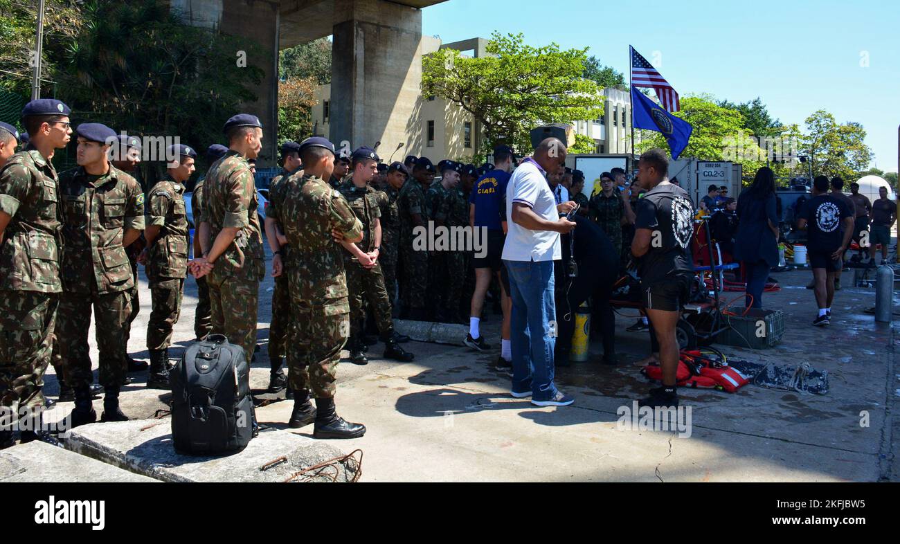 RIO DE JANEIRO – Brasilianische Militärmitglieder beobachten, wie Taucher der US-Marine, die der Mobile Diving and Salvage Unit 2 (MDSU-2) zugewiesen sind, während der UNITAS LXIII, 19. September 2022, Tauchoperationen durchführen. UNITAS ist die am längsten laufende maritime Übung der Welt. Dieses Jahr von Brasilien ausgerichtet, bringt es multinationale Kräfte aus Brasilien, Kamerun, Chile, Kolumbien, der Dominikanischen Republik, Ecuador, Frankreich, Guyana, Jamaika, Mexiko, Namibia, Panama, Paraguay, Peru, Südkorea, Spanien, das Vereinigte Königreich, Uruguay und die Vereinigten Staaten, die Operationen an und vor der Küste von Rio de Janeiro durchführen. Die Übung Stockfoto