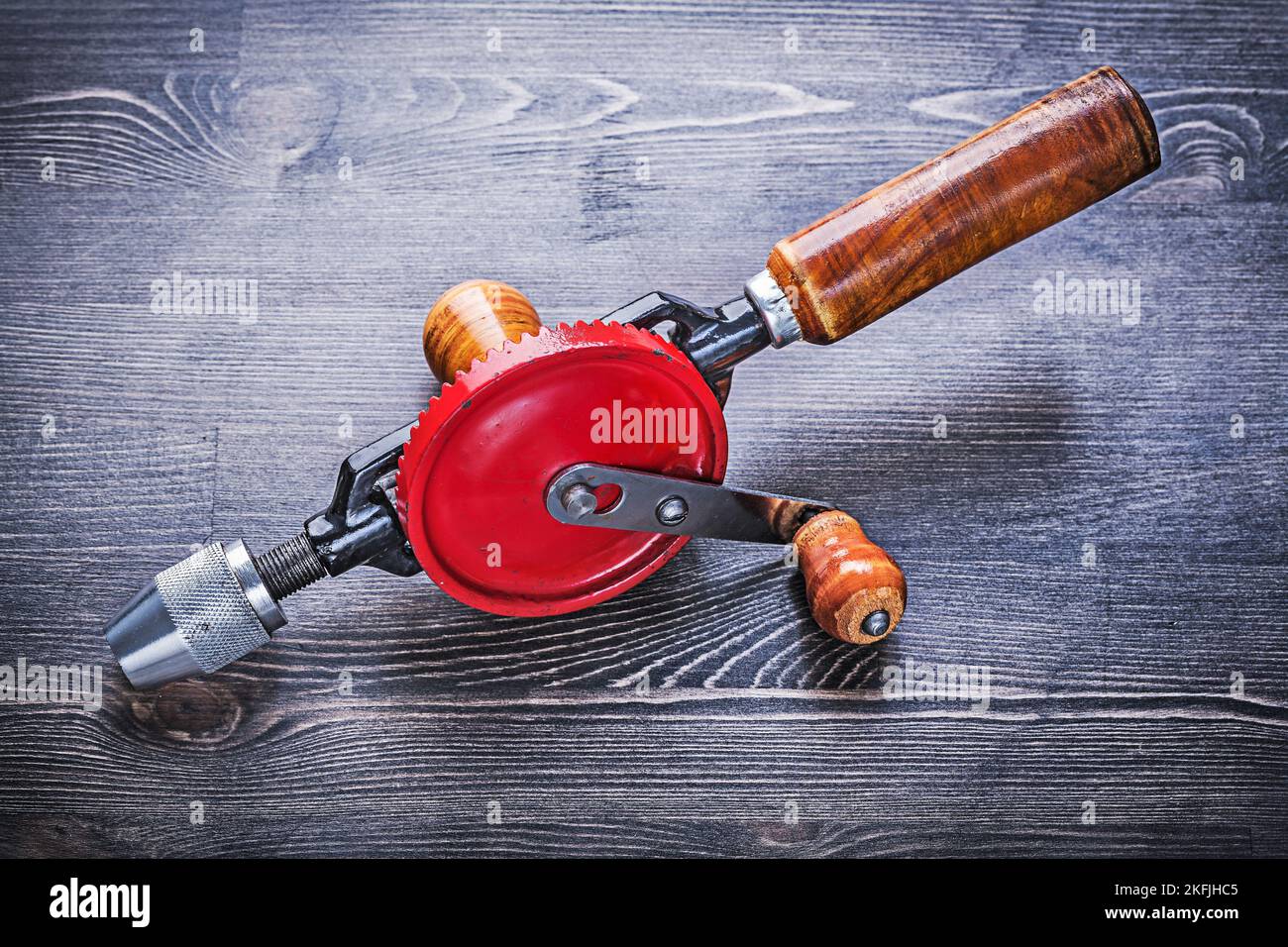 Vintage tragbare Bohrmaschine mit Holzgriff auf Holzbrett. Stockfoto