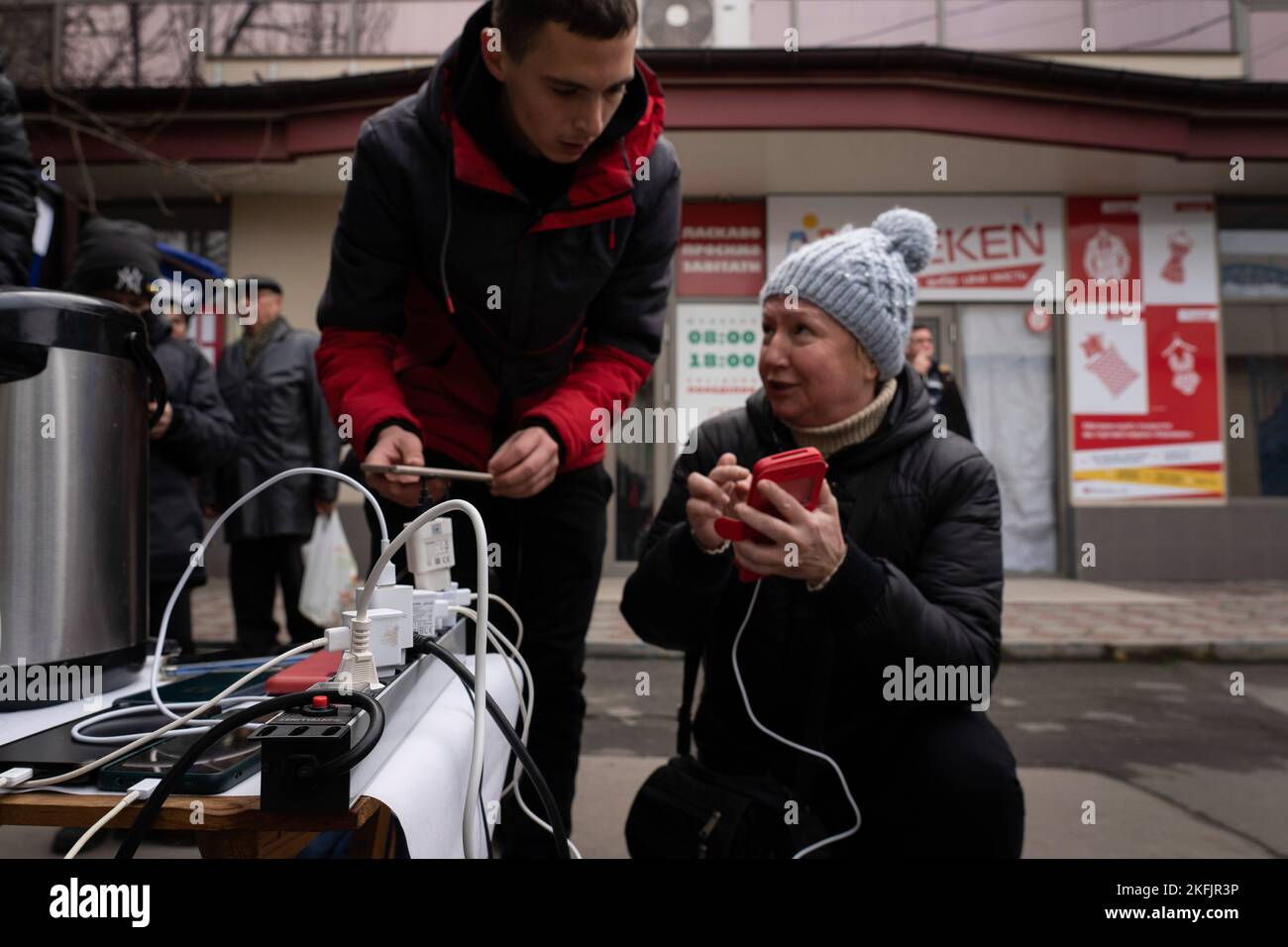 Cherson, Ukraine. 17.. November 2022. Bewohner werden gesehen, wie sie ihre Telefone an einer temporären Ladestation überprüfen und aufladen. Die Bewohner von Kherson sind immer noch überglücklich über die Befreiung der Stadt und setzen mehr als 8 Monate der Besetzung zu Ende. Dennoch verfügt die südliche regionale Hauptstadt noch immer über keinen Strom, kein Wasser und ein Minimum an Signal- und Nahrungsmittelversorgung. Kredit: SOPA Images Limited/Alamy Live Nachrichten Stockfoto