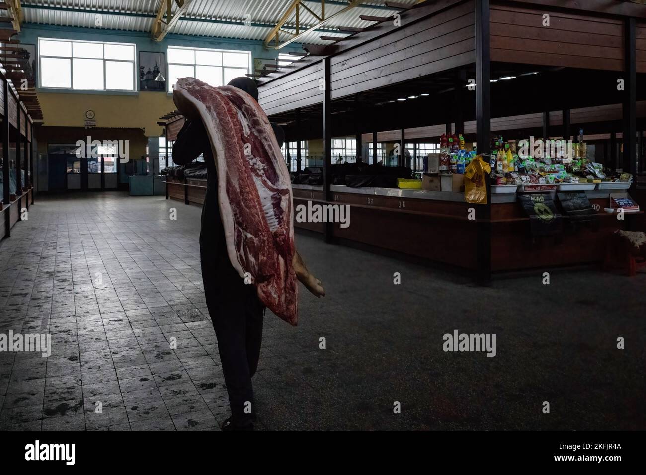 Cherson, Ukraine. 17.. November 2022. Ein Metzger wird auf dem Markt gesehen, wie er ein Schwein über die Schulter trägt. Die Bewohner von Kherson sind immer noch überglücklich über die Befreiung der Stadt und setzen mehr als 8 Monate der Besetzung zu Ende. Dennoch verfügt die südliche regionale Hauptstadt noch immer über keinen Strom, kein Wasser und ein Minimum an Signal- und Nahrungsmittelversorgung. Kredit: SOPA Images Limited/Alamy Live Nachrichten Stockfoto