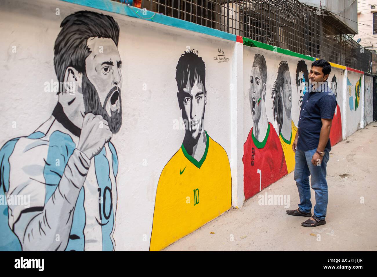 Dhaka, Bangladesch. 17.. November 2022. Ein Mann schaut auf Graffiti, die die Fußballstars Lionel Messi, Neymar, Cristiano Ronaldo, Ronaldinho und Diego Maradona vor der FIFA-Weltmeisterschaft 2022 an einer Wand im KM das Lane in Dhaka feiern. Kredit: SOPA Images Limited/Alamy Live Nachrichten Stockfoto