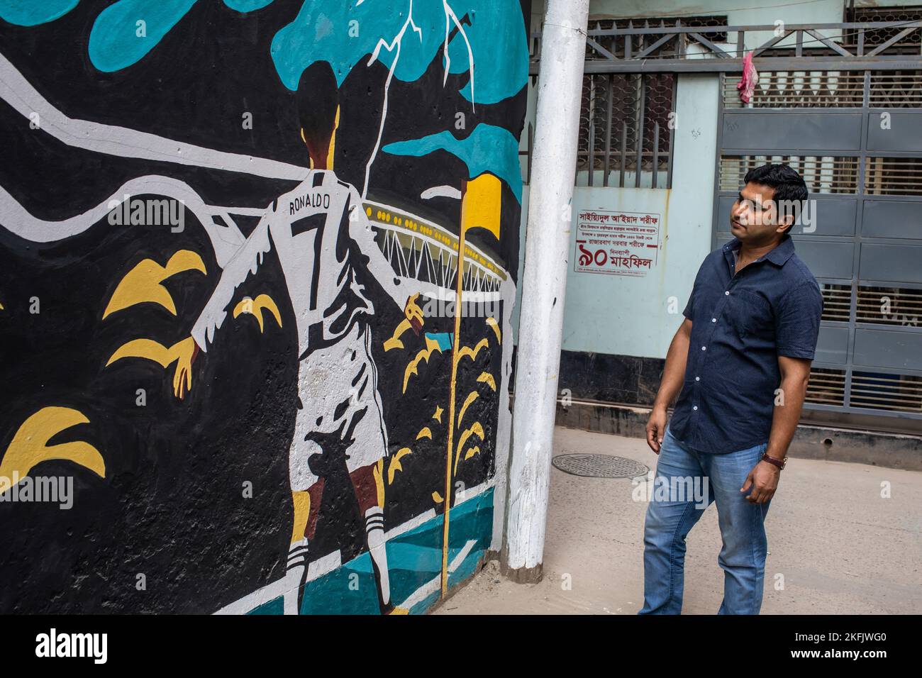 Dhaka, Bangladesch. 17.. November 2022. Ein Mann sieht sich die Graffiti des berühmten Fußballspielers Cristiano Ronaldo an einer Wand in einer Gasse in Dhaka an. (Foto: Sazzad Hossain/SOPA Images/Sipa USA) Quelle: SIPA USA/Alamy Live News Stockfoto