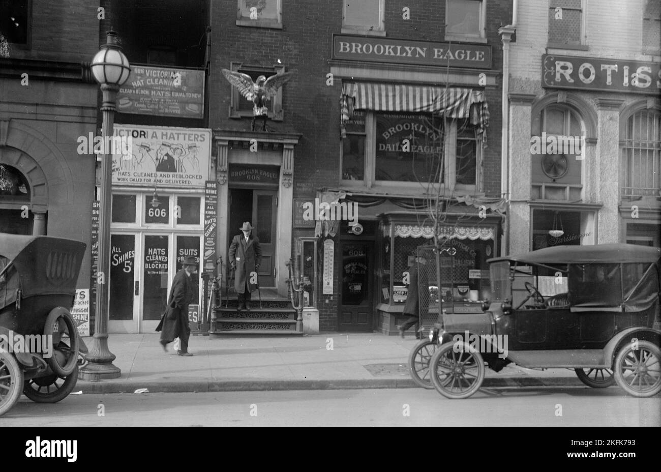 Brooklyn Daily Eagle, 1916. Zeitungsbüro, New York City. Schilder: 'Victoria Hut Reinigung - Hatters - Hüte gereinigt und neu blockiert - gleich neu'; 'Shoe Shine'; 'Anzüge gepresst'; 'Tait &amp; Co. Suburban Real Estate'. Stockfoto