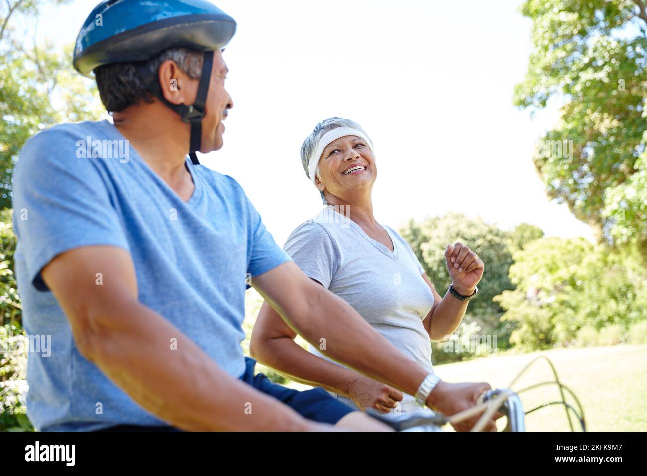 Gesund ist glücklich. Ein glückliches Seniorenpaar geht auf eine Fahrradtour und joggen gemeinsam im Freien. Stockfoto