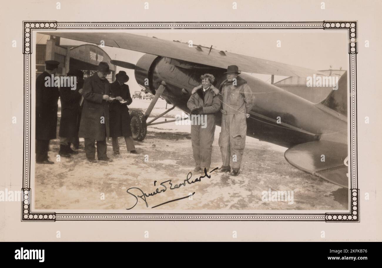 Amelia Earhart und ihr Mann George Putnam stehen neben einem Flugzeug. Ca. 1930. Das Bild wurde von Amelia Earhart signiert Stockfoto