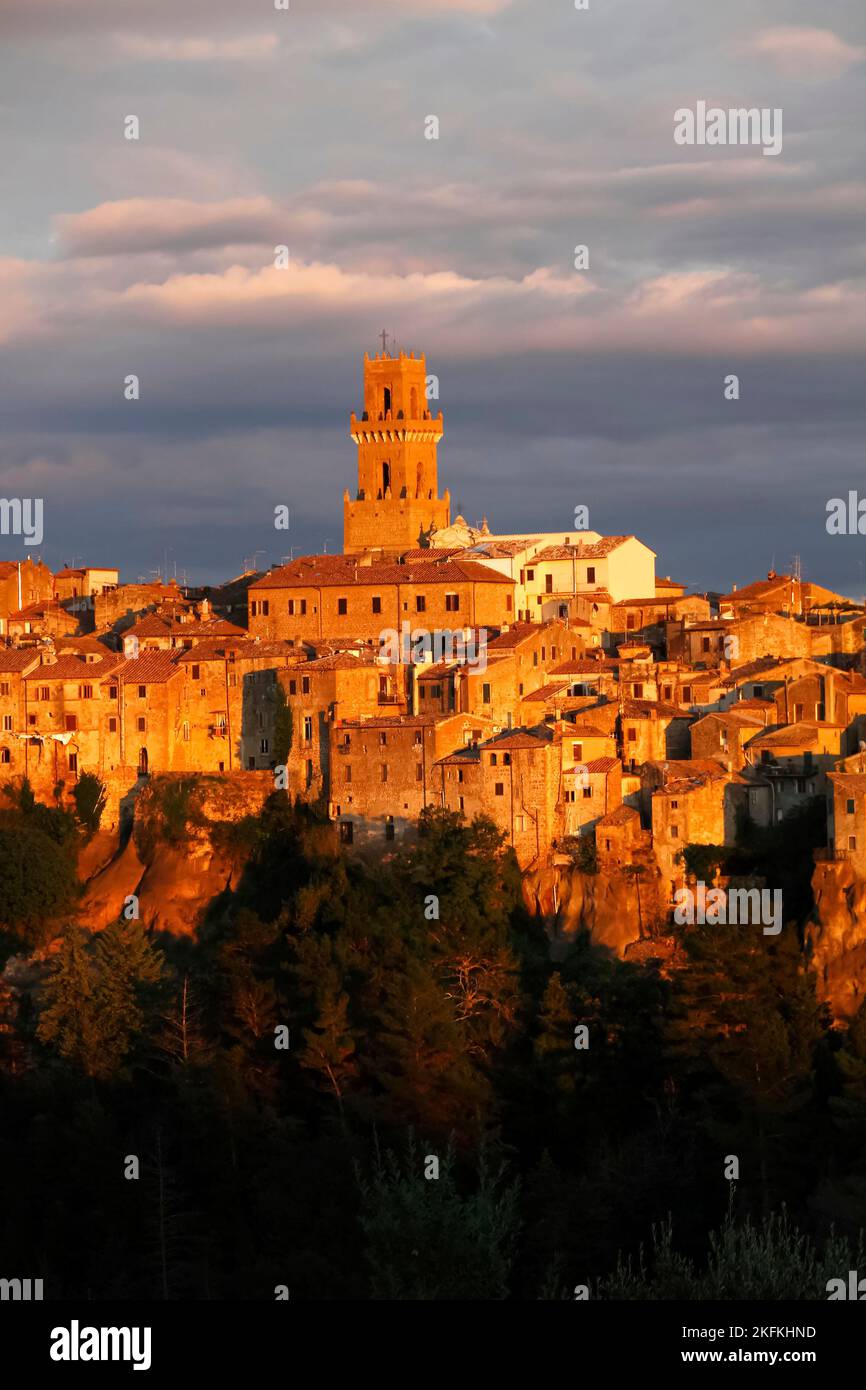 Nahaufnahme und Detail der mittelalterlichen Stadt Pitigliano leuchtet im Abendlicht mit Kathedrale Santi Pietro e Paolo und Turm in der Mitte, Maremma, Provin Stockfoto
