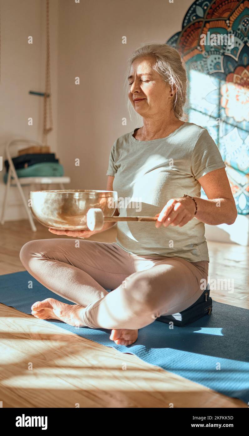 Meditation, ältere Frau und Achtsamkeit, Zen und Yoga im Fitnessstudio mit tibetischer Klangschale, Balance und Frieden. Wellness, spirituelle und Stockfoto