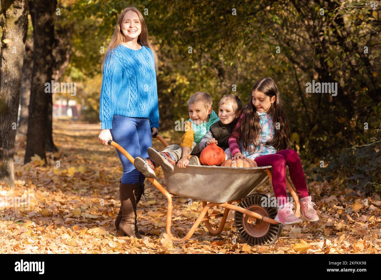 Mutter haben Spaß mit Kindern, verwenden Sie Garten Schubkarre Stockfoto