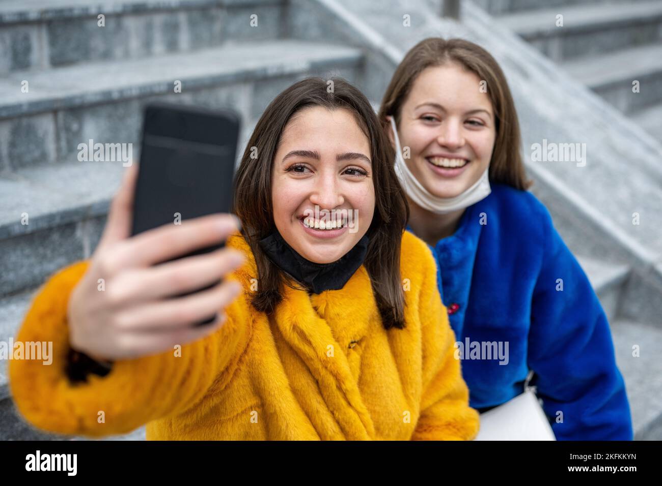 Ein paar junge Frauen, die ein Selfie machen, tragen Gesichtsmask, zwei Mädchen der Generation Z, die Spaß im sozialen Netzwerk haben, Mode-Influencer, der Inhalte veröffentlicht Stockfoto