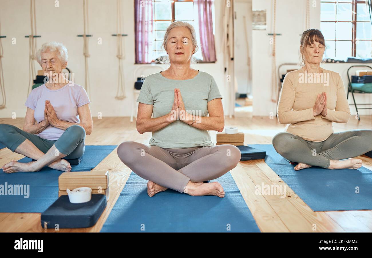 Yoga, Meditation und ältere Frauen mit Zen und Yogi-Instruktor im Fitnessstudio mit Wellness, Gesundheit und Achtsamkeit. Gleichgewicht, spirituell und Frieden Stockfoto