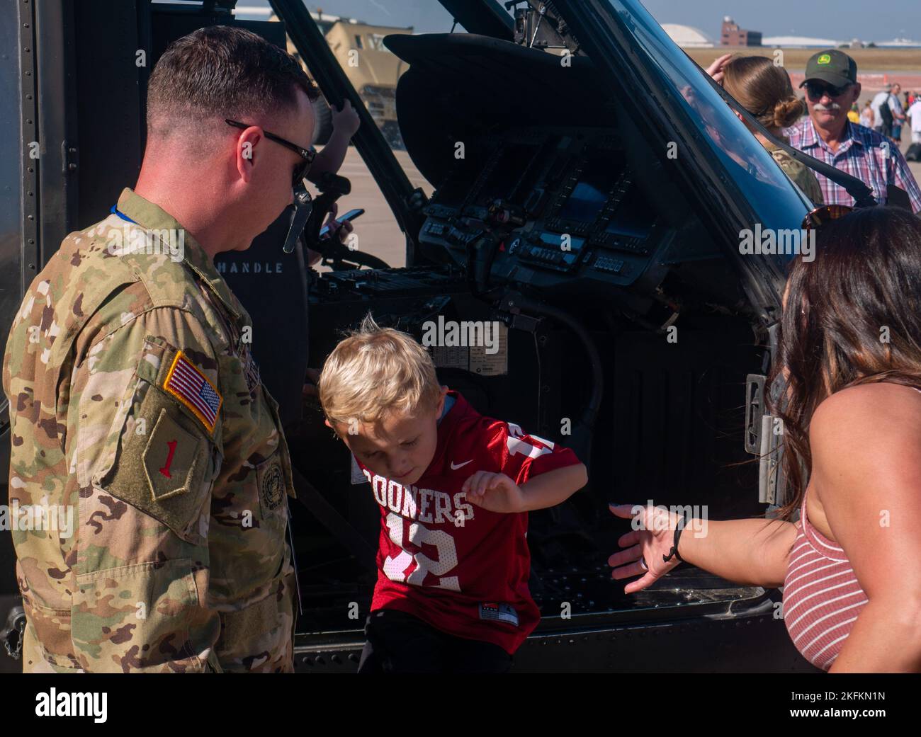 Der Chief Warrant Officer der US-Armee 2 David Shattuck, ein Blackhawk-Pilot, der dem Angriffsaufklärungsbataillon 1., dem Aviation Regiment 1., der Combat Aviation Brigade 1., der Infanterie-Division 1., zugewiesen wurde, zeigt Gästen der Frontiers in Flight Airshow das Innere einer UH-60 Black Hawk auf der McConnell Air Force Base, Wichita, Kansas, 24. September 2022. Shattuck nahm zusammen mit anderen Soldaten der CAB von 1. an der jährlichen gemeinsamen Luftshow für die lokale Gemeinschaft Teil. Stockfoto