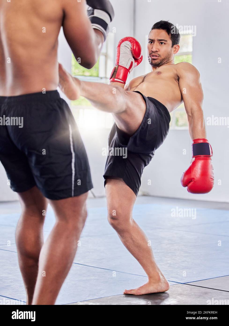 Fitness, Kickboxen und mma-Training, Training und Kampftraining im Fitnessstudio mit Männern, Handschuhen und Power-Kick. Kampf, Athlet oder Kampfkunst, Coaching oder Stockfoto