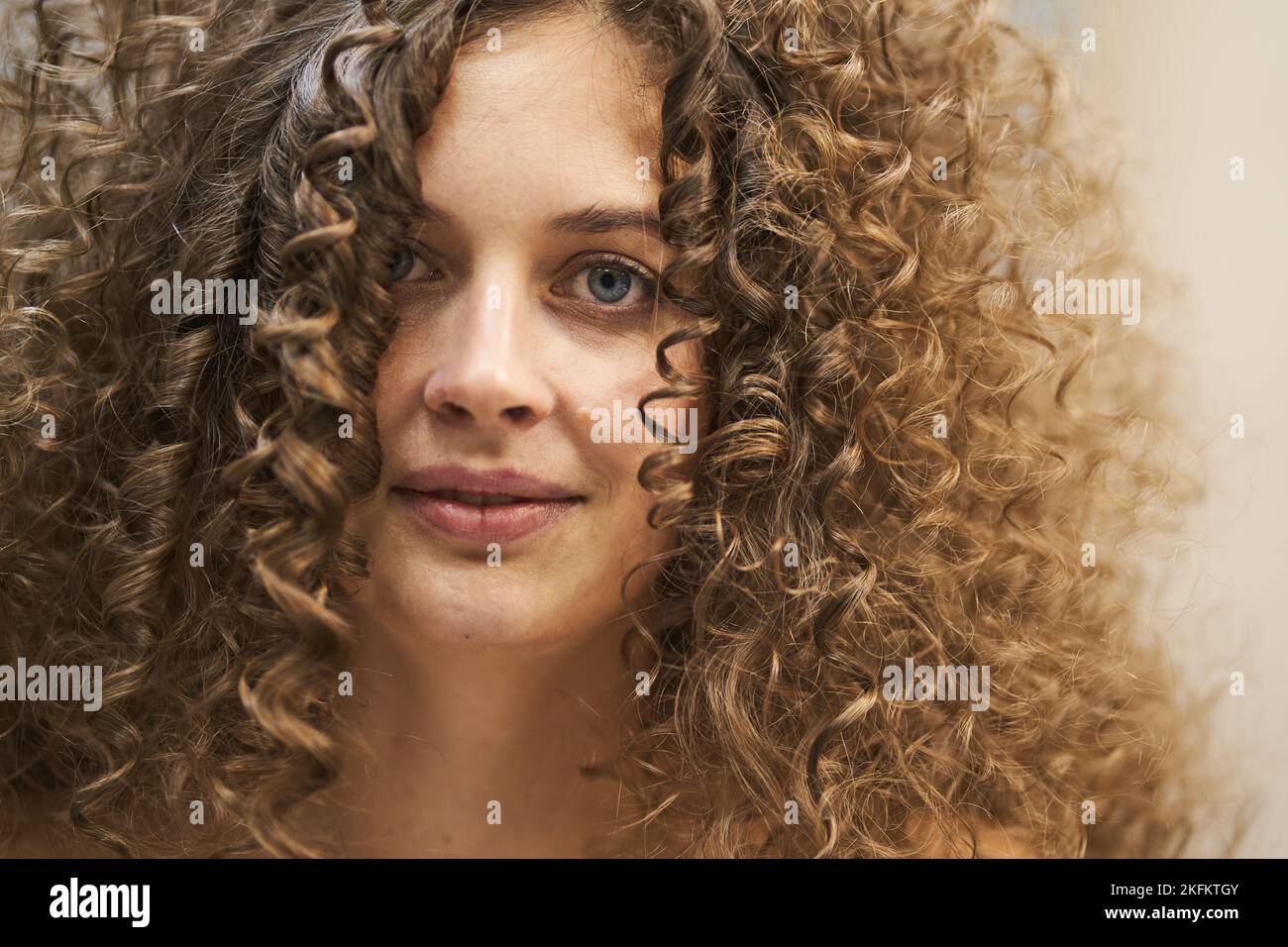 Ein schönes Porträt einer kaukasischen Frau mit sauberer, gesunder Haut und Afro-Locken. Die natürliche Schönheit der Frauen, das Konzept des Glücks. Hochwertige Fotos Stockfoto