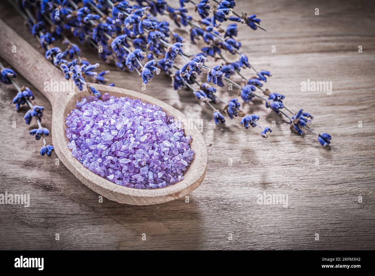 Getrockneter duftender heilender Lavendel Meersalz Holzlöffel auf Holzbrett Spa-Behandlungskonzept. Stockfoto