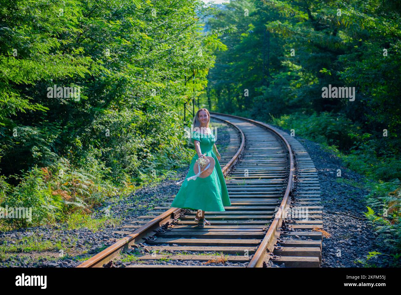 Ein Mädchen in einem grünen Kleid läuft auf der Bahn Stockfoto