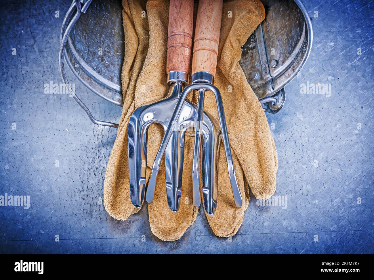 Metall Eimer Hand Rechen Kelle Gabel Leder Schutzhandschuhe auf metallischen Hintergrund Gartenkonzept. Stockfoto