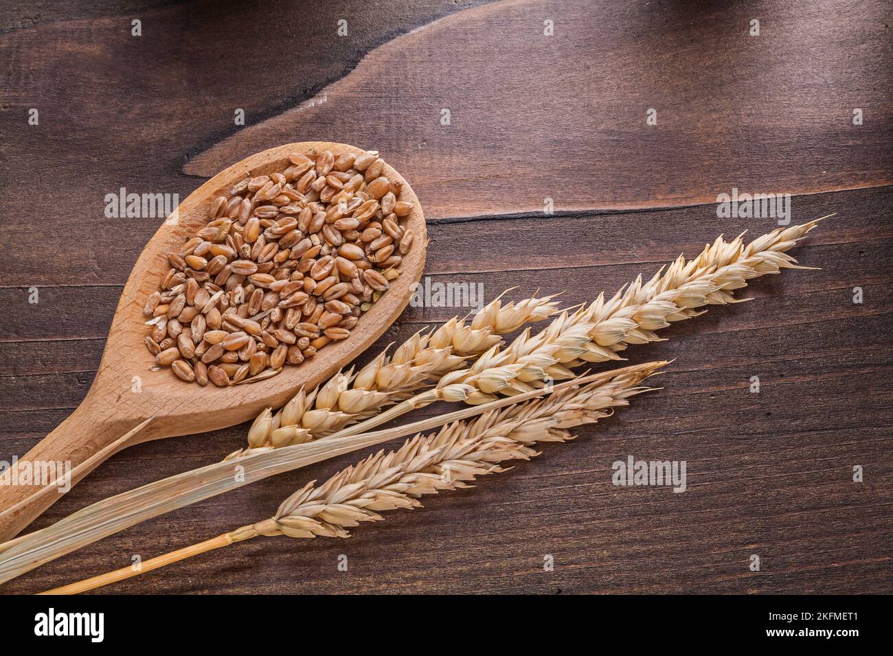 Sorns in Holzlöffel und Ähren von Weizen auf alten Brett Essen und Trinken Konzept Stockfoto