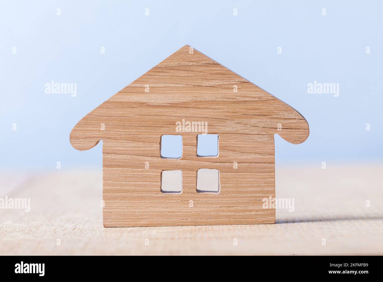 Symbol des Holzhauses auf blauem und hölzernem Hintergrund Stockfoto