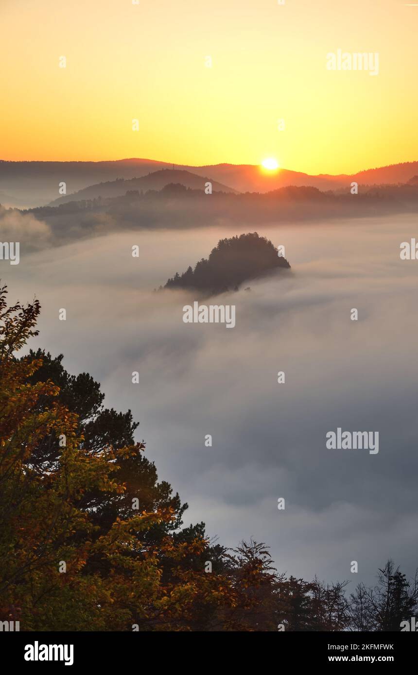 Schöne und einzigartige Berglandschaft. Die Sonne, die hinter den Hügeln in der Morgenlandschaft aufgeht. Foto aufgenommen in Sokolica Peak, Polen. Stockfoto