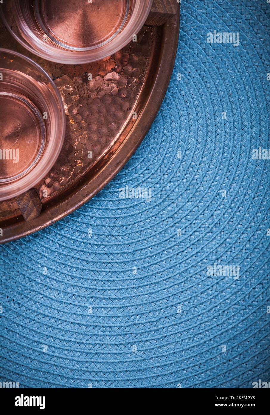 Klassisches Kupfertablett und Teebecher auf blauem Tischtuch. Stockfoto