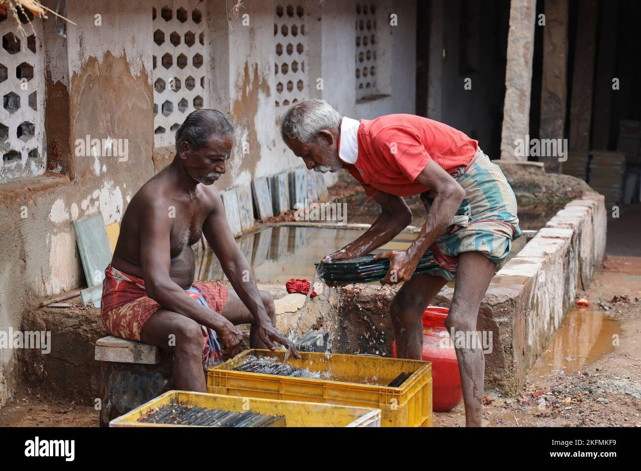 Mann, der Attangudi-Fliesen in Attangudi, Tamil Nadu, Indien, wäscht Stockfoto