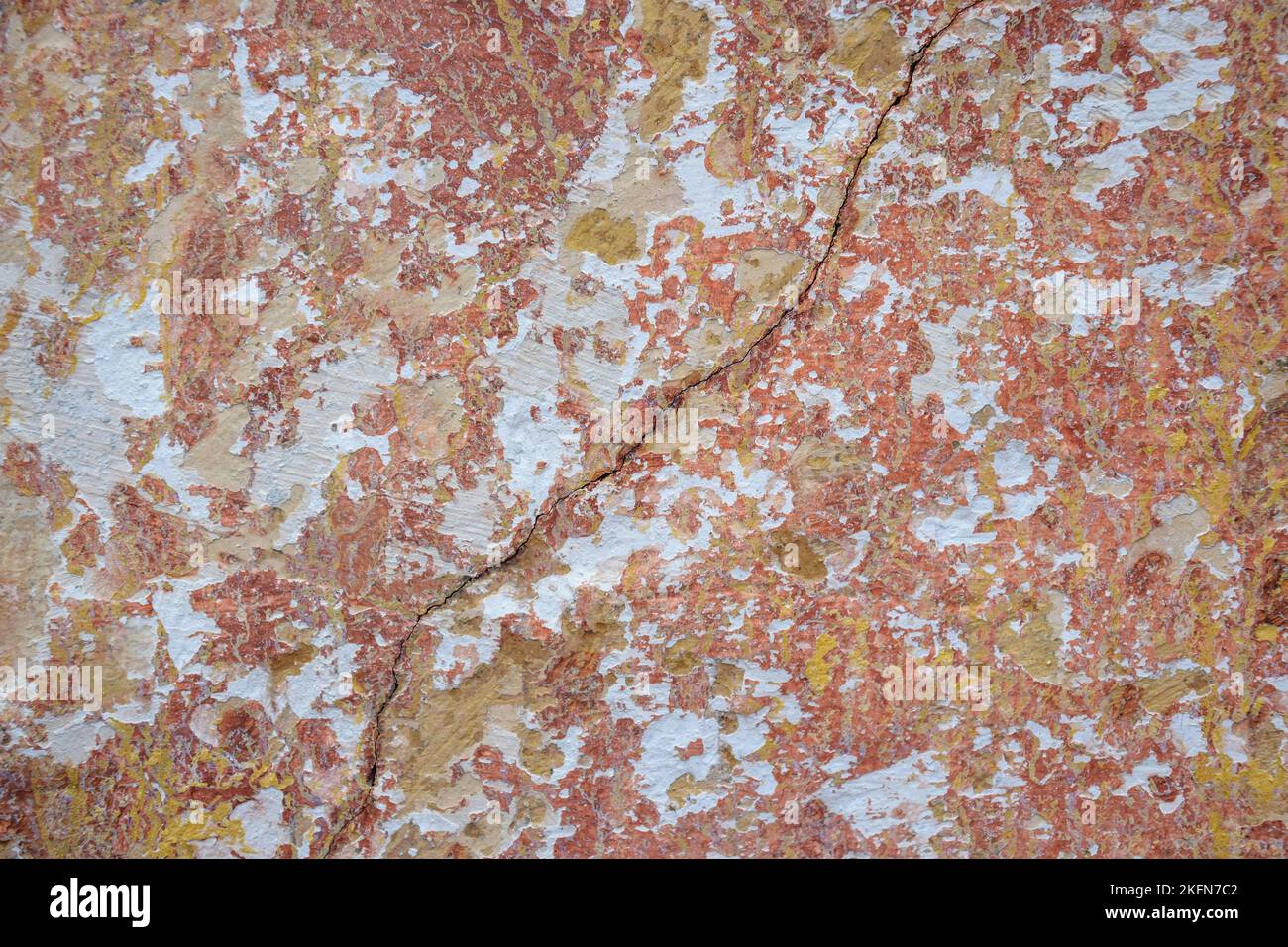 Großer Riss auf bemalten bunten verwitterten Wand mit Überresten von Farbe des alten Gebäudes, abstraktes Bild von Riss, Detail. Folgen des Erdbebens. Stockfoto Großer Riss auf bemalten bunten verwitterten Wand mit Überresten von Farbe des alten Gebäudes, abstraktes Bild von Riss, Detail. Folgen des Erdbebens. Stockfoto