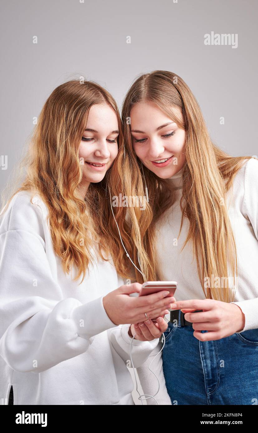 Junge Frauen Mädchen hören zusammen Musik Streaming-Inhalte Spaß beim Ansehen von Videos genießen Video-Chat mit Freunden reden machen Gesten fac Stockfoto