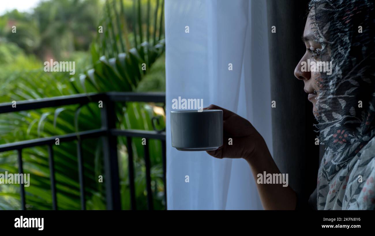 Muslimische Frauen, die morgens auf dem Balkon Tee trinken Stockfoto
