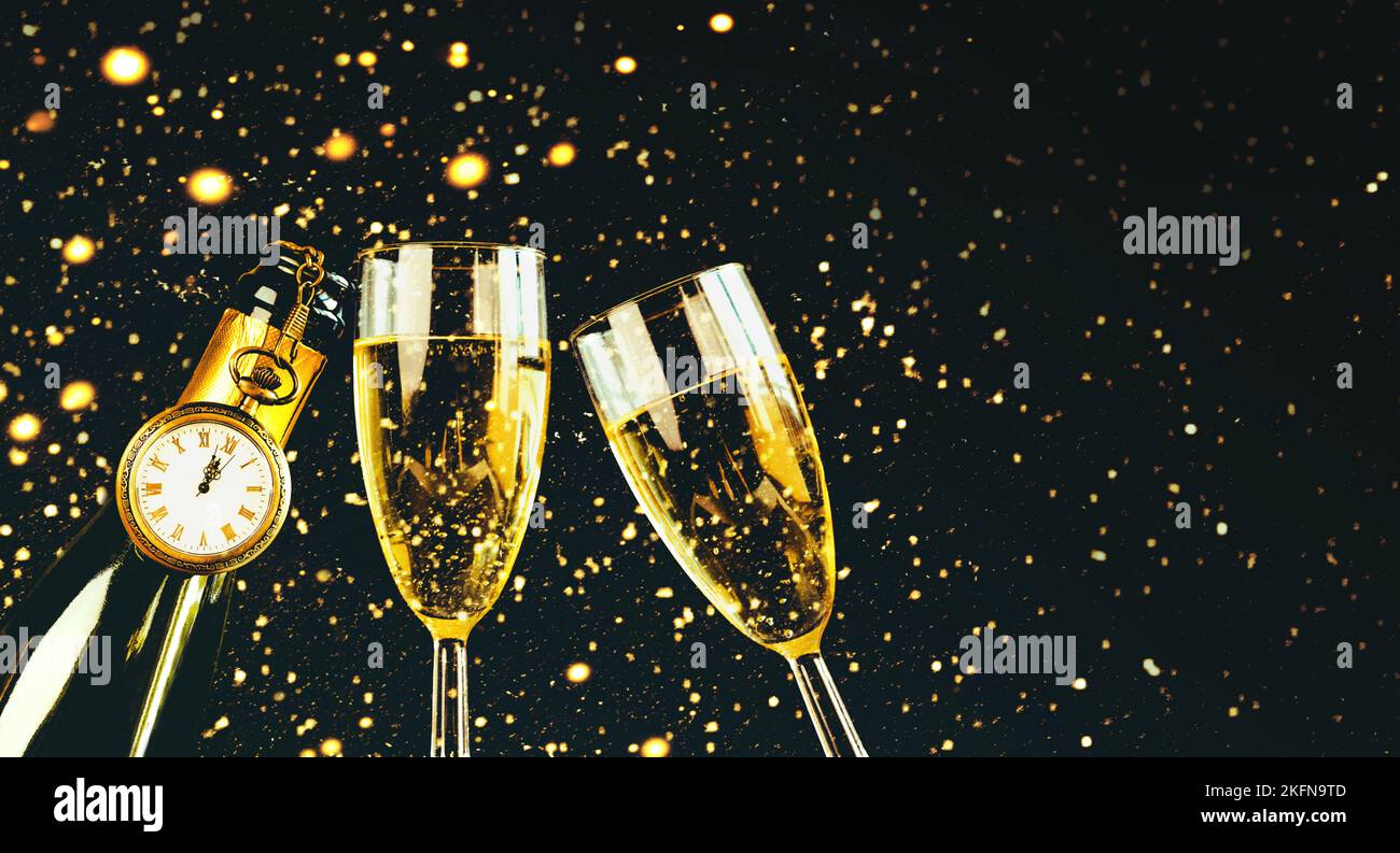 Frohes neues Jahr. Champagnerflasche mit zwei Gläsern, glitzernder Glitzer mit Kopierfläche auf schwarzem Hintergrund. Silvester Feier Konzept backgroun Stockfoto
