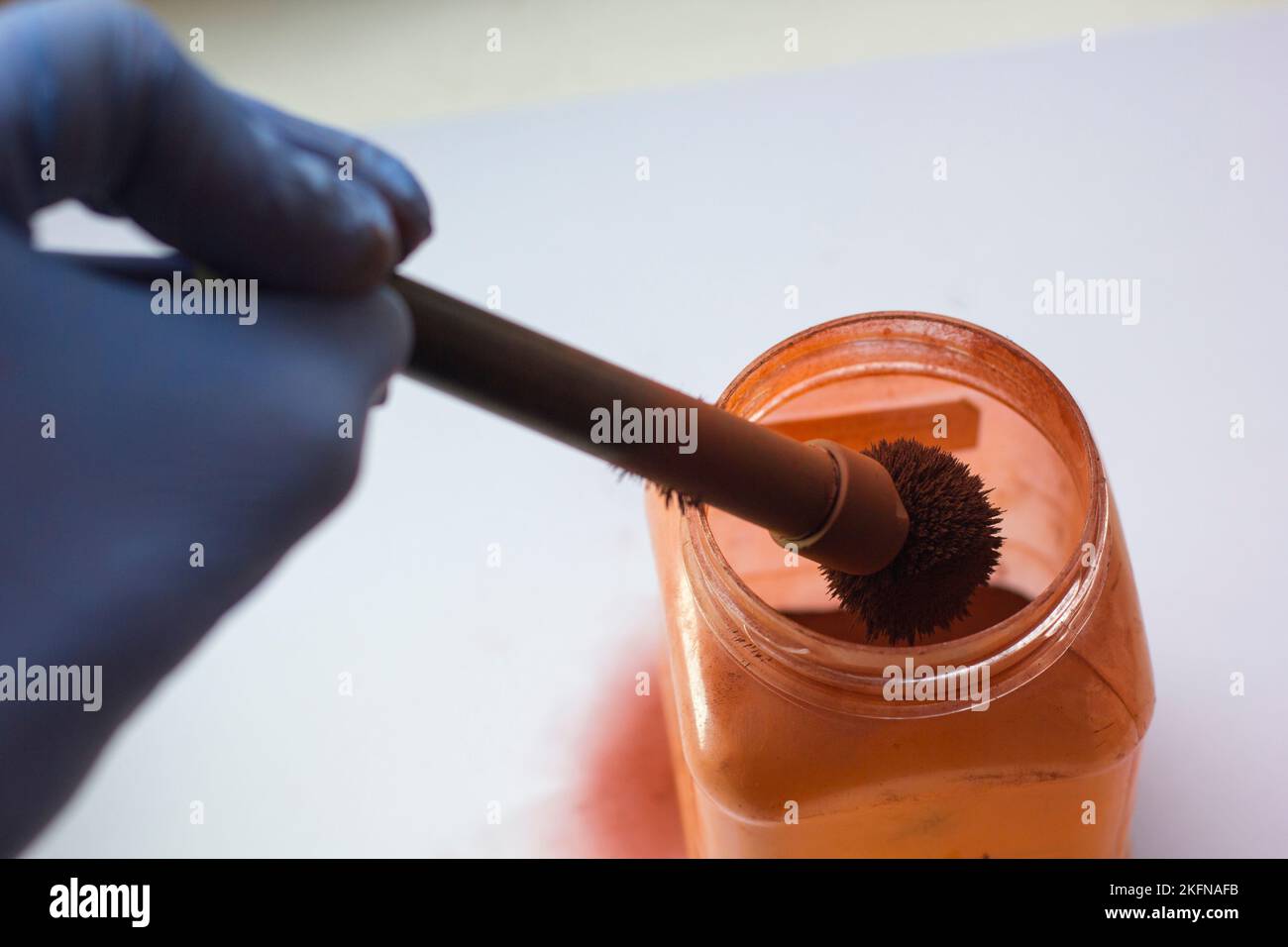Hand eines Experten in Gummihandschuh, Magnetbürste und Fingerabdruckpulver Stockfoto