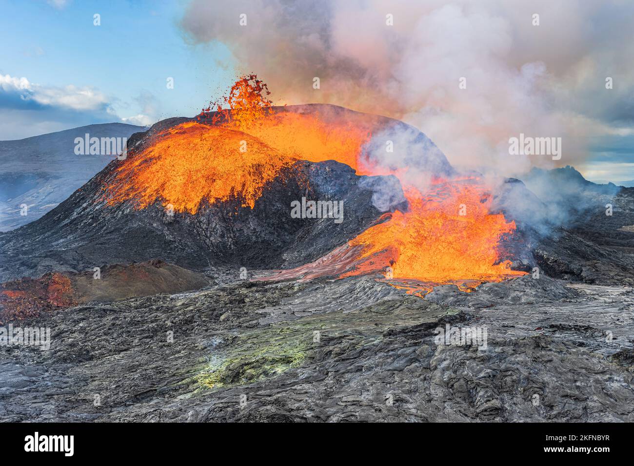 Starker Lavafluss aus einem aktiven Vulkan auf der Rekjanes-Halbinsel in Island. Vulkankrater am Tag mit Sonnenschein. Kaltes Magma um die Krater. Stockfoto