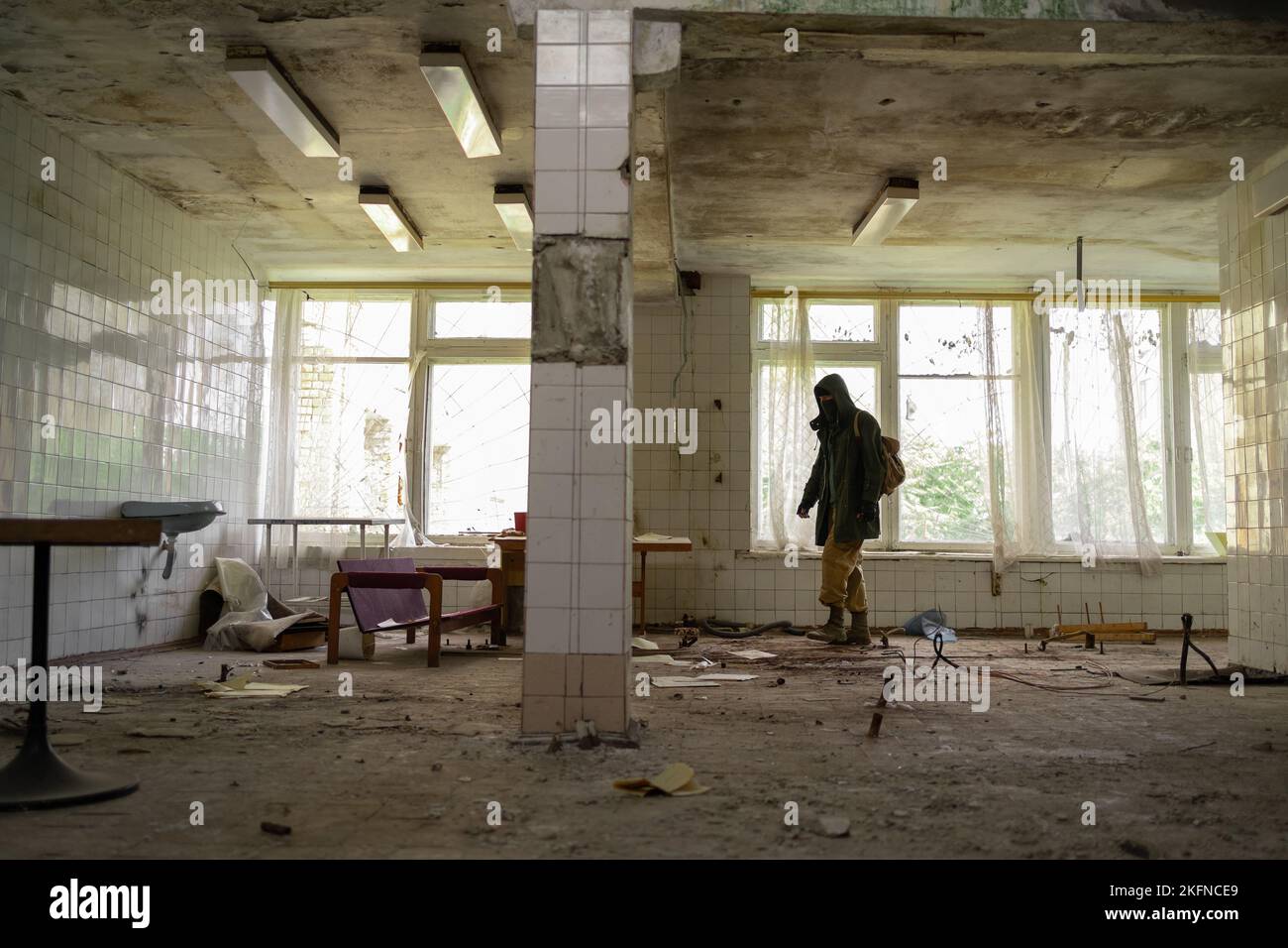 Ein nuklearer Überlebender nach der Apokalypse in verlassenen Gebäuden, ein Stalker-Leben nach dem Krieg, ein Mann, der zu Fuß in einer post-apokalyptischen Welt unterwegs ist. Stockfoto