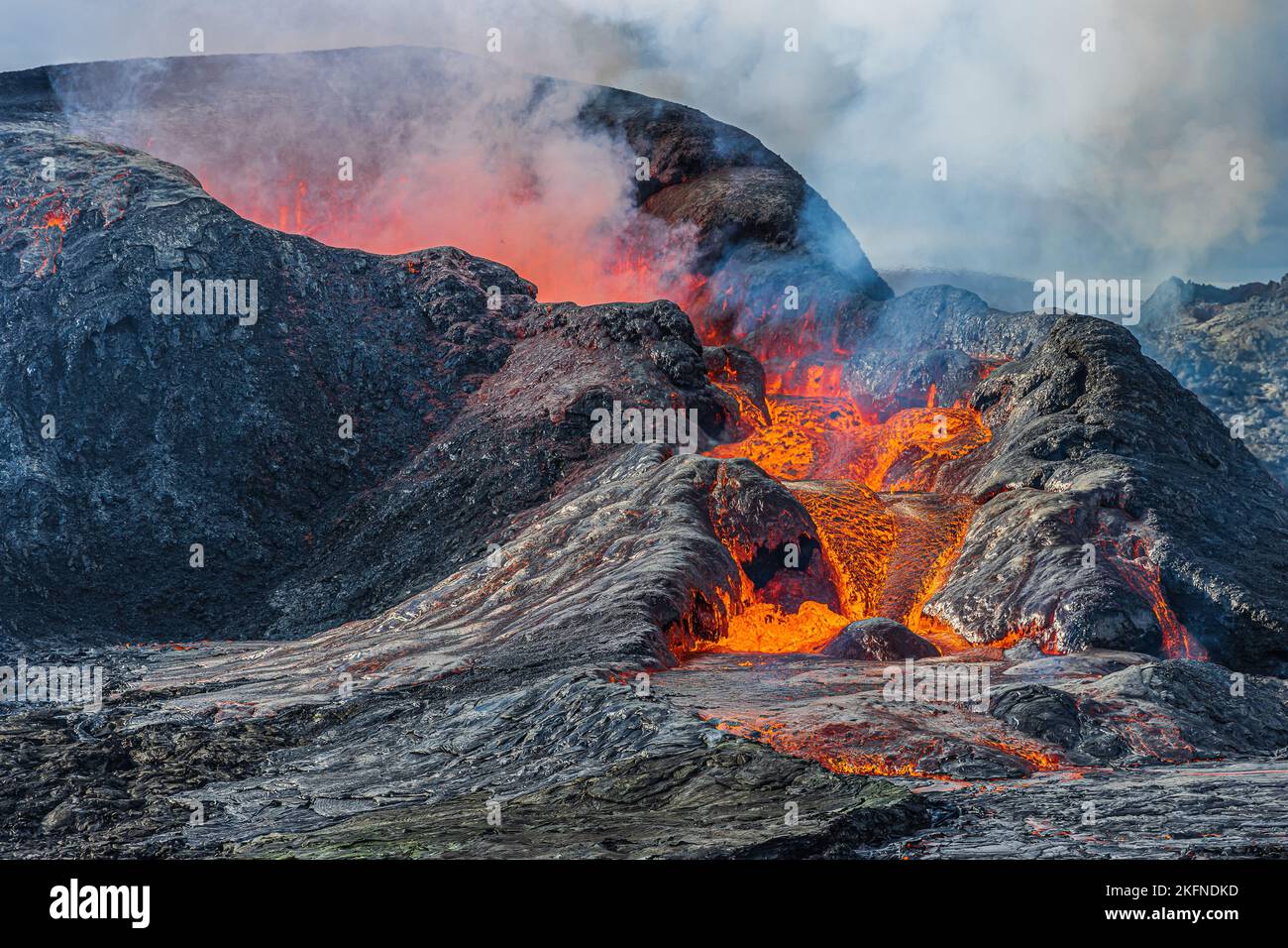 Details einer Vulkankrateröffnung. Lava fließt in geringer Menge aus dem Krater. Aktiver Vulkan in Island auf der Halbinsel Reykjanes. Rauch und Dampf Stockfoto