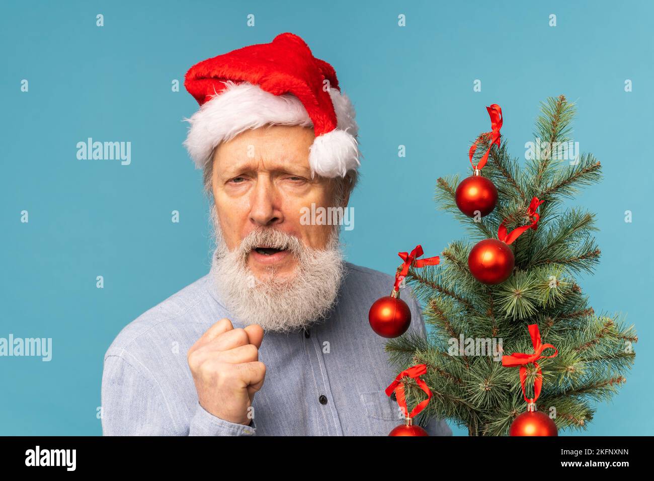 Der wütende Weihnachtsmann macht Kindern Angst, der Mann trägt den weihnachtsmann und zeigt aggressive Emotionen - das Weihnachtskonzept mit negativer und schlechter Stimmung Stockfoto