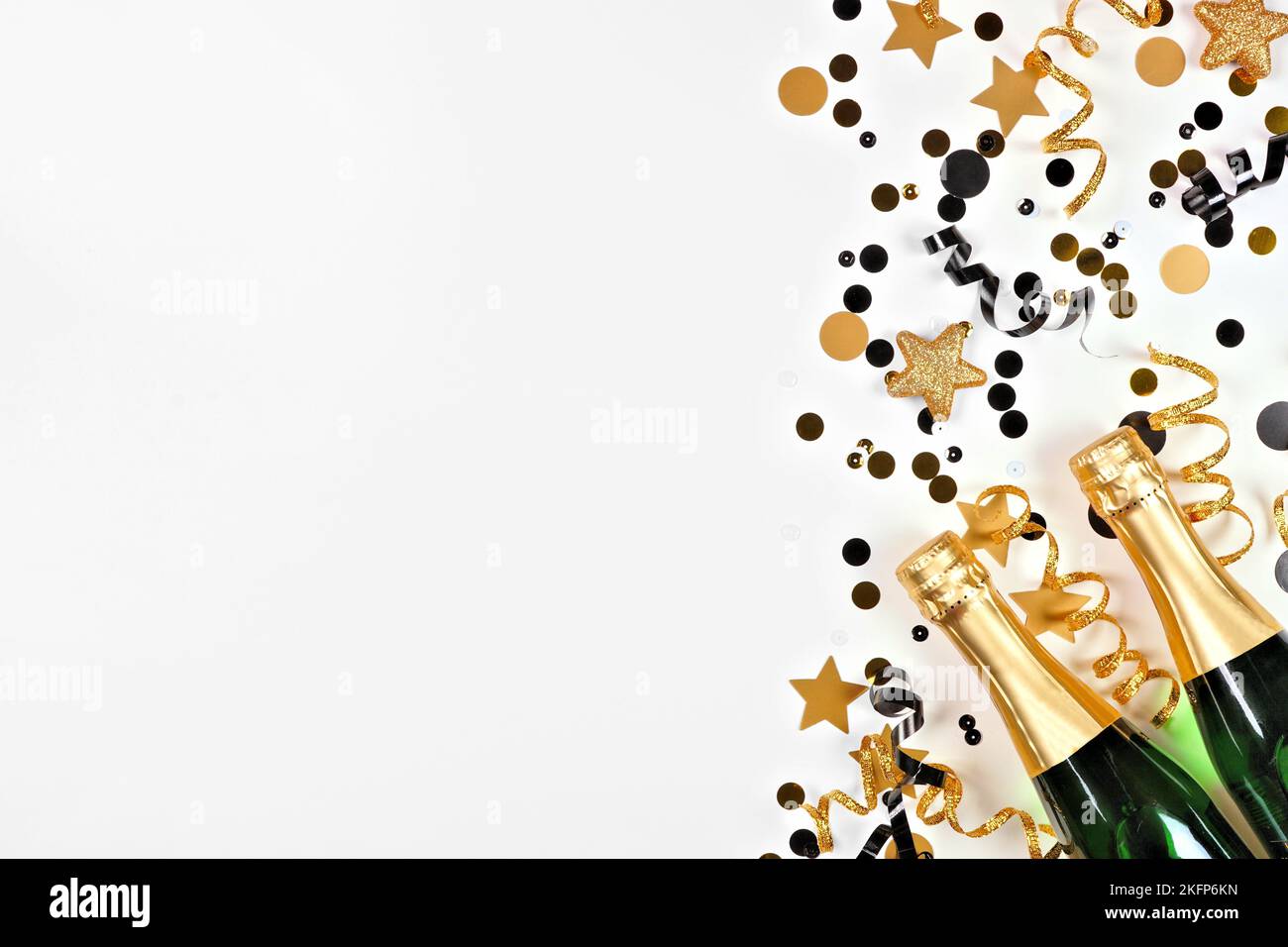 Silvester Seitenrand aus Gold und schwarzem Konfetti, Luftschlangen und Champagner. Oben über einem weißen Hintergrund. Stockfoto