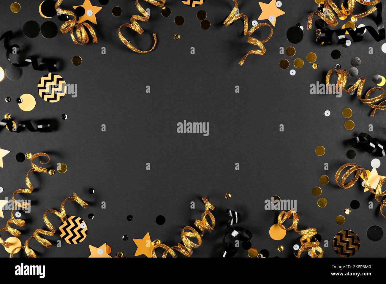 New years Party Rahmen aus glänzendem schwarz und Gold schwarz und Gold Streamer und Konfetti. Draufsicht auf schwarzem Hintergrund. Stockfoto