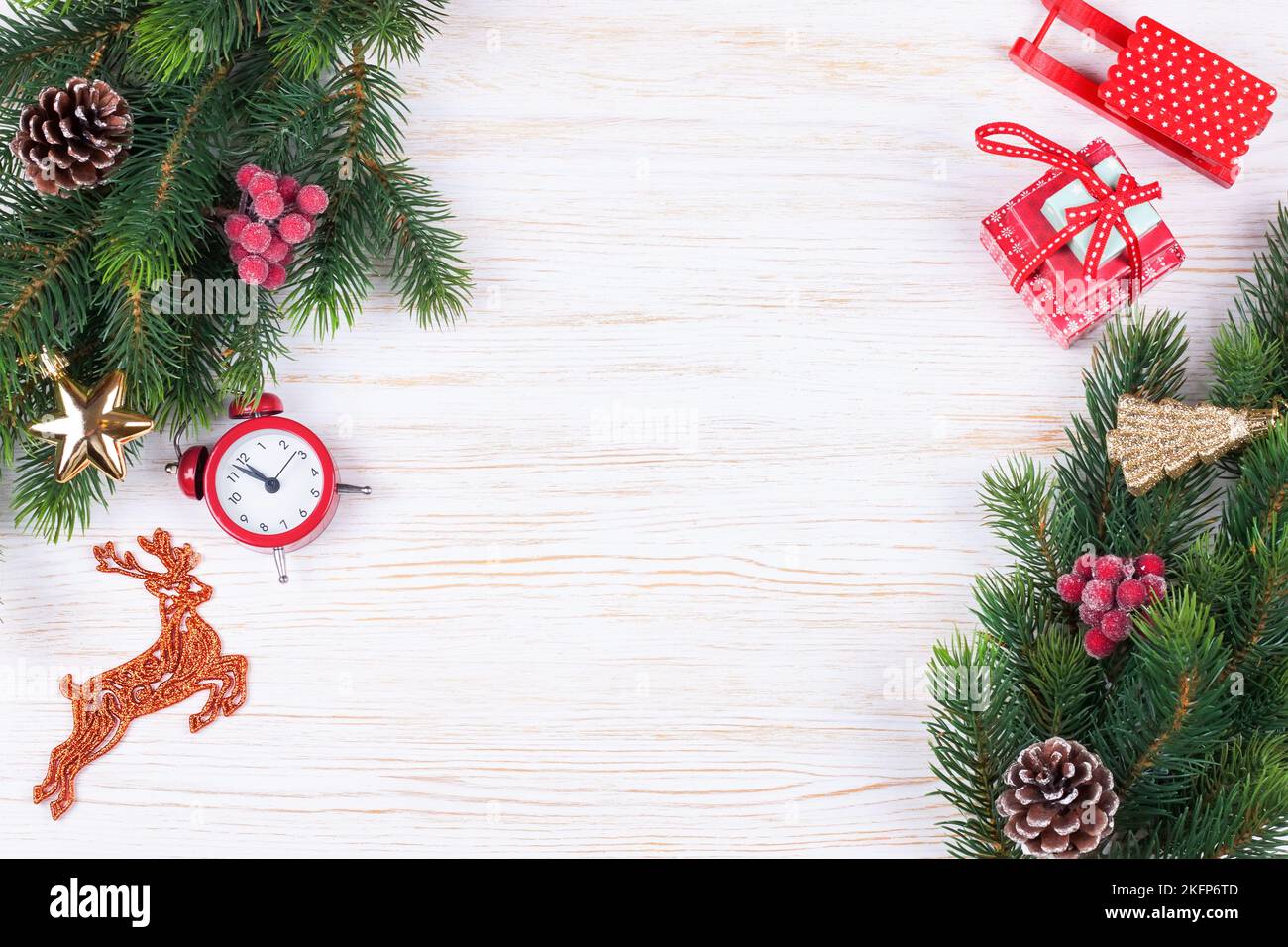 Weihnachten und Neujahr Komposition. Weihnachtsschmuck, Tannenzweig, Girlande, roter weihnachtsmann Hut, Uhr, Geschenk auf weißem Holzhintergrund. Flach Stockfoto