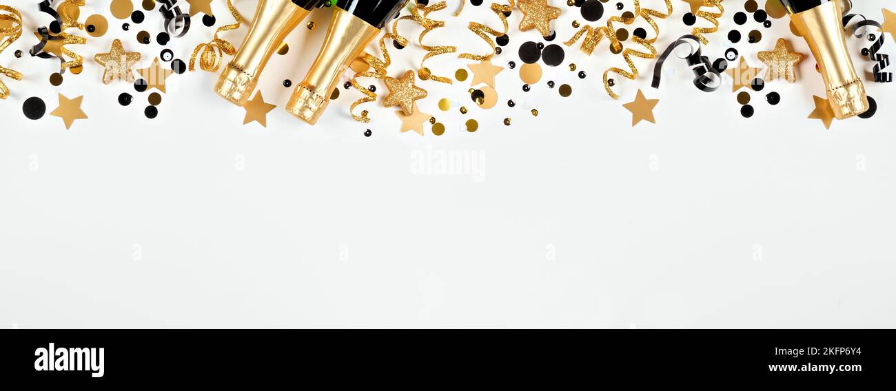 Silvester obere Grenze aus Gold und schwarzen Konfetti, Luftschlangen und Champagner. Overhead-Ansicht über einem weißen Banner-Hintergrund. Stockfoto