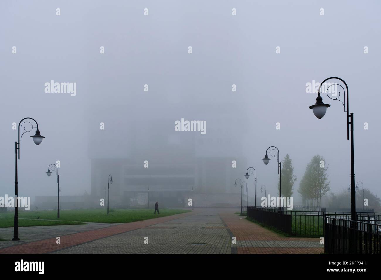 Öffentlicher Park und Silhouette hohes Gebäude im Nebel Stockfoto