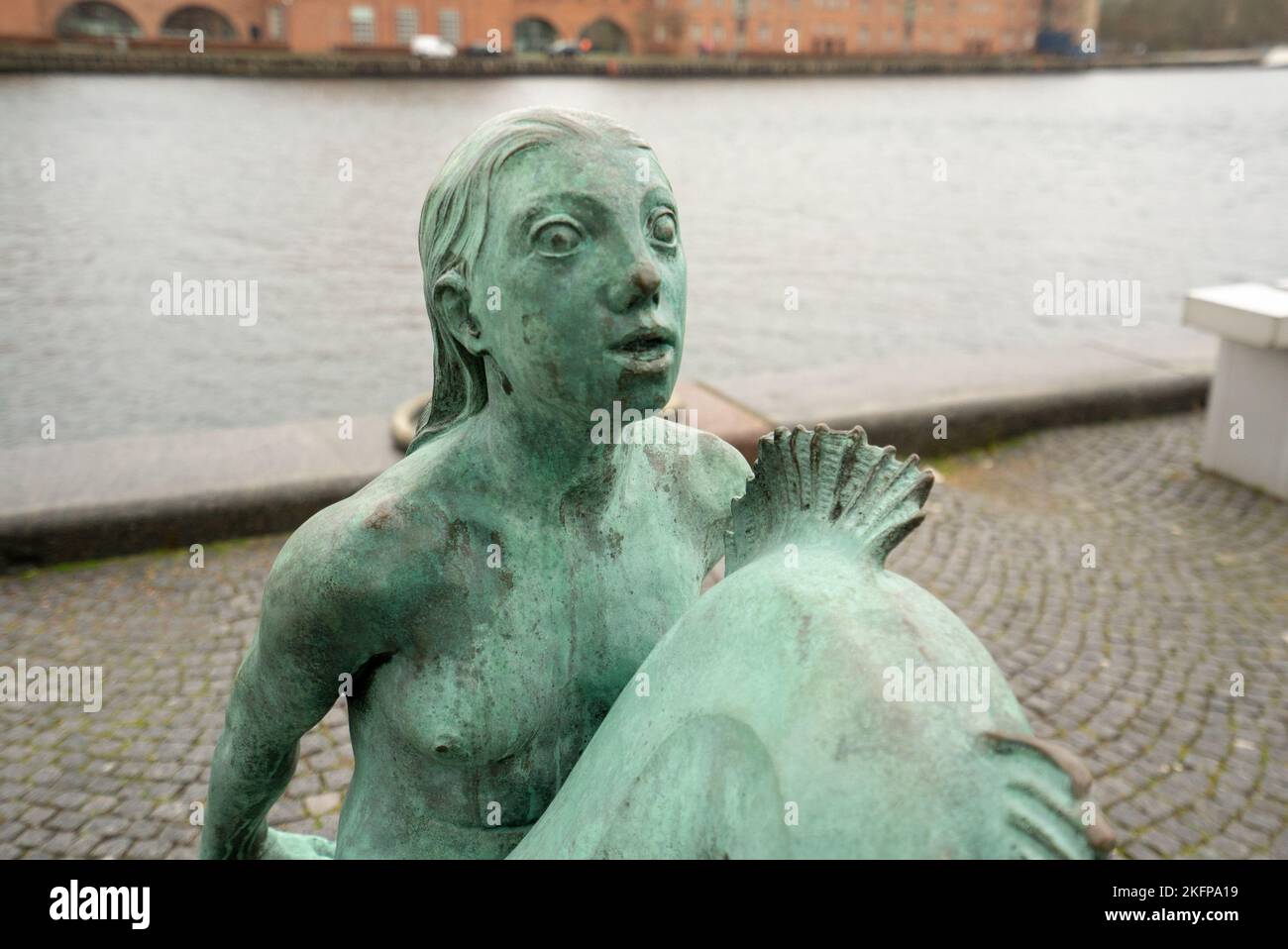 Statue der Meerjungfrau (Carl-Nielsen) vor der Königlichen Dänischen Bibliothek in Kopenhagen, Dänemark. Die Black Diamond Meerjungfrau Statue von Anne Marie Carl-Nielsen. Stockfoto