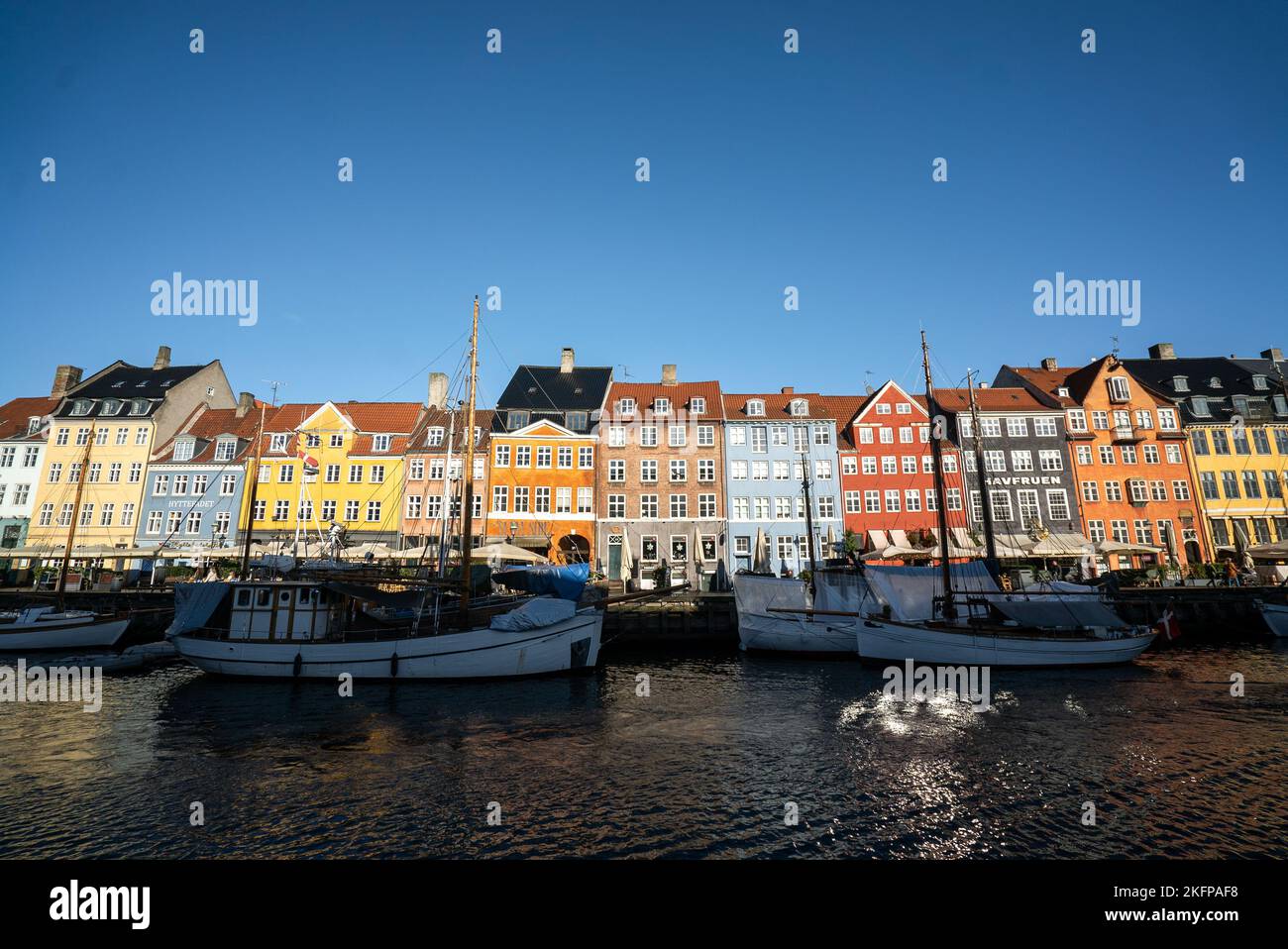 Die farbenfrohen Straßen von Kopenhagen, Dänemark, entlang des Nyhavn Quayside, an einem sonnigen Tag mit blauem Himmel. Stockfoto