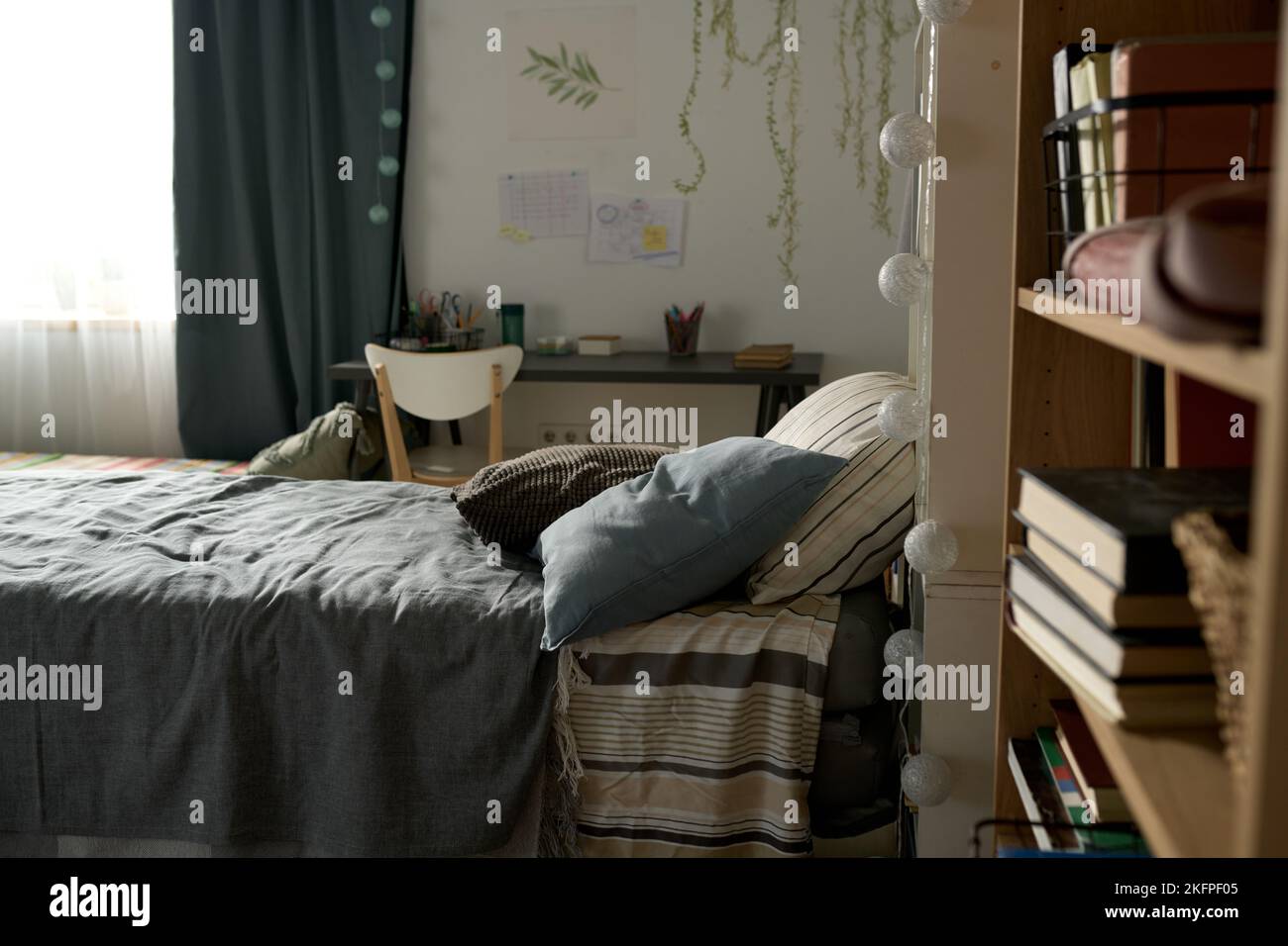 Horizontales Bild eines modernen Kinderzimmers mit komfortablem Bett, Schreibtisch und Bücherregal Stockfoto
